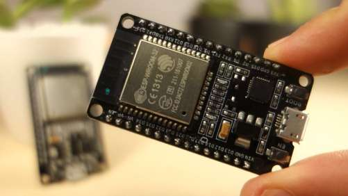 Placa ESP32 DEVKIT sostenida en la mano